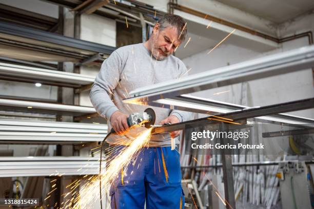 metaal snijden met schijfmolen in werkplaats - metal workshop stockfoto's en -beelden