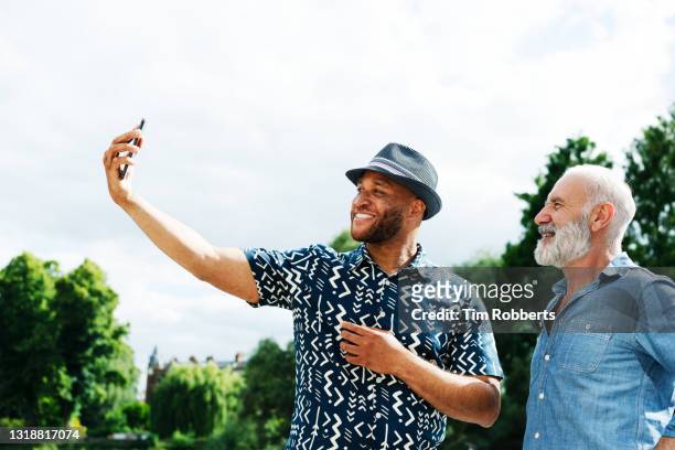 two men with smart phone - mid adult men stock pictures, royalty-free photos & images