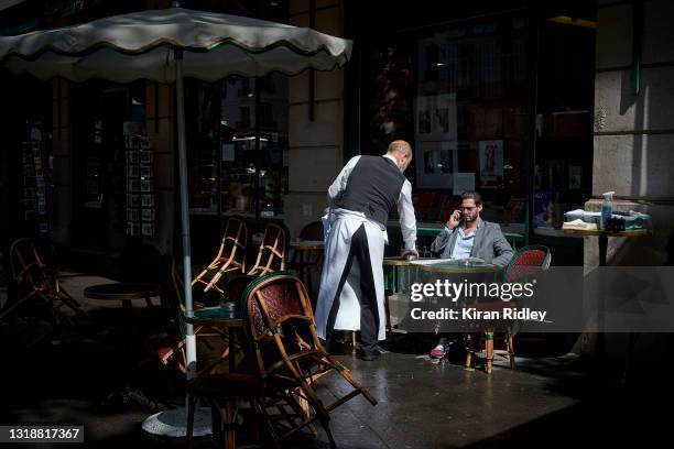 Waiter serves a Parisian at Cafe de Flore in Paris as Covid-19 restrictions are lifted allowing Cafes and Restaurants across France to re-open for...