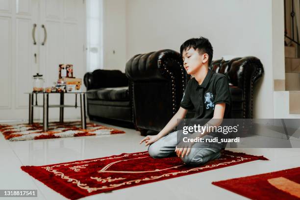 het aziatische moslimjong geitje bidt in huis - salah islamic prayer stockfoto's en -beelden