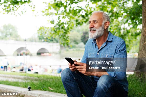 man using smart phone, looking up - hipster senior man stock pictures, royalty-free photos & images