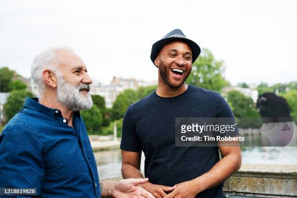 two men laughing with each other - diverse mature men stock pictures, royalty-free photos & images