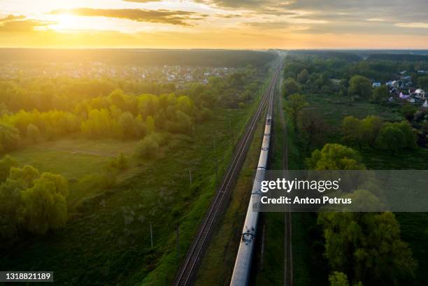 freight train on the railroad at sunrise. aerial view - boxcar stock-fotos und bilder