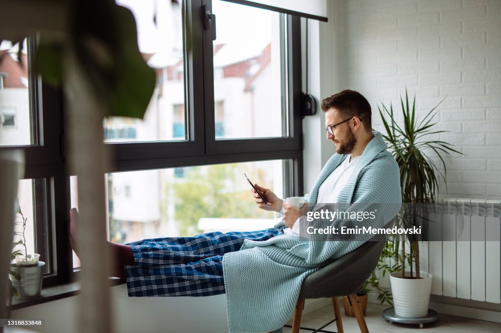 A Man Using Phone Young Man Using Mobile Phone While Resting At Home High-Res Stock Photo ...