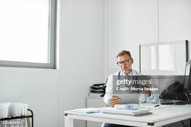 doctor explaining through video call in clinic - clinic imagens e fotografias de stock