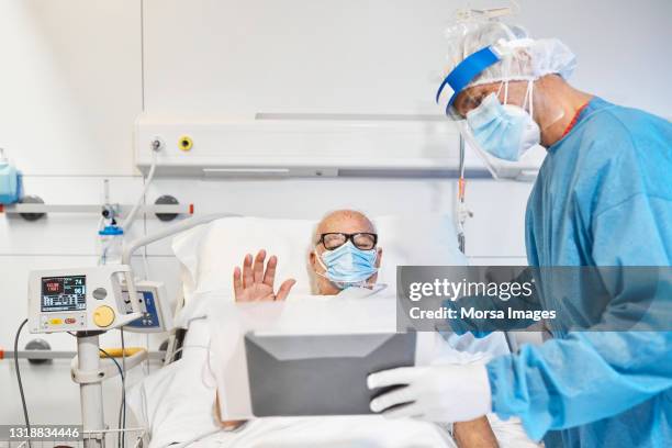 doctor helping patient to video call in icu - pensioners demonstrate in spain stock pictures, royalty-free photos & images