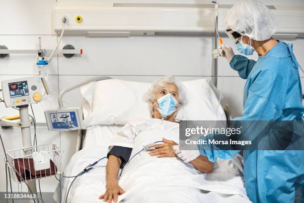 doctor examining patient in icu during covid-19 - hospital ventilator ストックフォトと画像