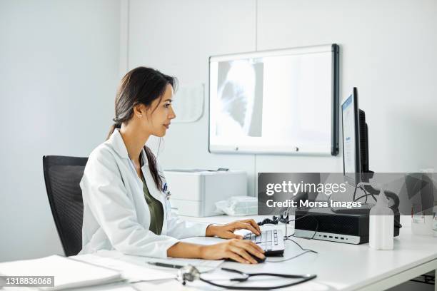 female doctor working at desk in clinic - examination room fotografías e imágenes de stock