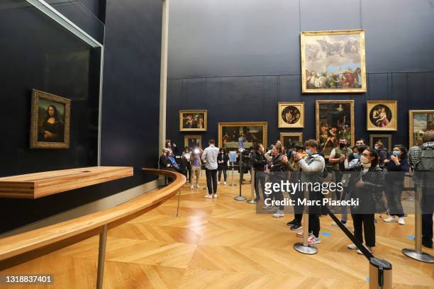 Visitor photographs the painting 'La Joconde' The Mona Lisa by Italian artist Leonardo Da Vinci on display in a gallery at Louvre on May 19, 2021 in...