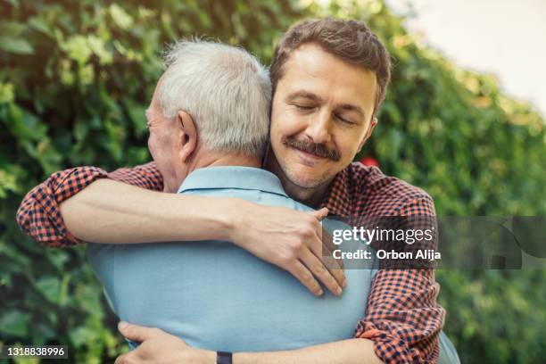 man embracing father at birthday party - son imagens e fotografias de stock