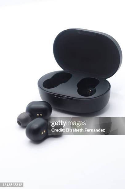 high angle view of wireless stereo earbuds black and charging case - headphones isolated foto e immagini stock