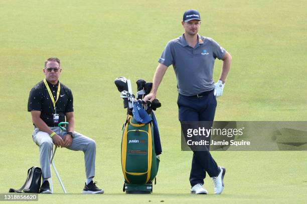 Justin Rose of England waits to play a shot as golf instructor Sean Foley looks on during a practice round prior to the 2021 PGA Championship at...