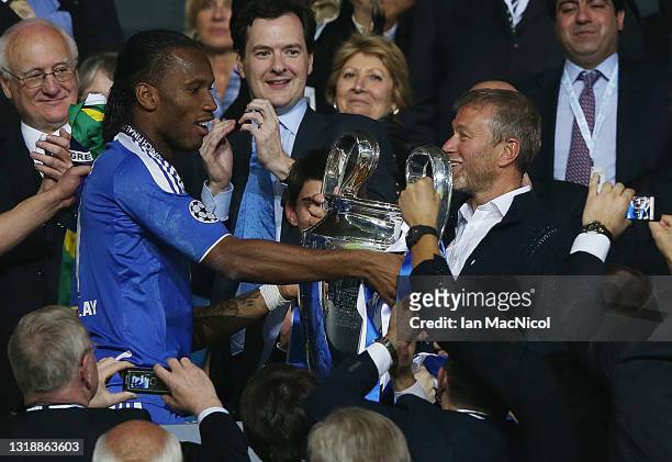 Chelsea player Didier Drogba presents Roman Abramovic with the Champions League trophy after winning the penalty shoot out during UEFA Champions...