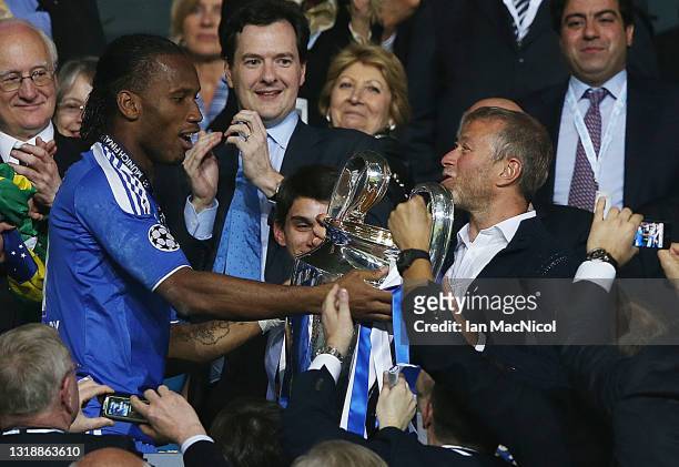 Chelsea player Didier Drogba presents Roman Abramovic with the Champions League trophy after winning the penalty shoot out during UEFA Champions...