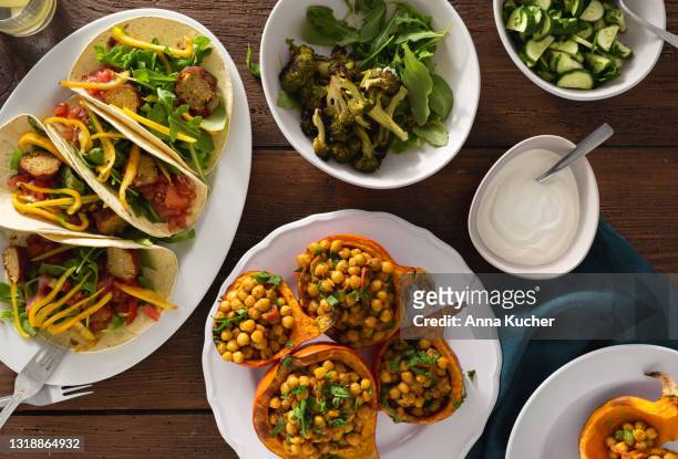 overhead view herfst eettafel met gebakken pompoen met kikkererwten curry, tortilla met falafel en salade - indian food stockfoto's en -beelden