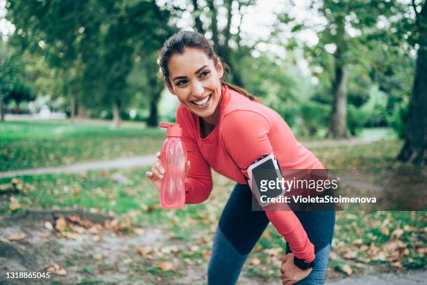 femme sportif prenant une pause après l’entraînement courant. - fitness armband photos et images de collection