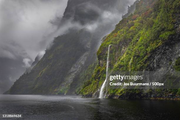scenic view of waterfall against sky,doubtful sound,fiordland,new zealand - doubtful sound patea stock pictures, royalty-free photos & images