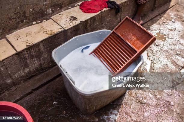 plastic washboard in a bucket of soapy water. - washboard laundry stock pictures, royalty-free photos & images