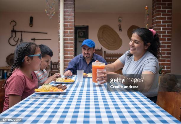 glückliche lateinamerikanische familie beim gemeinsamen mittagessen zu hause - latin father and son stock-fotos und bilder