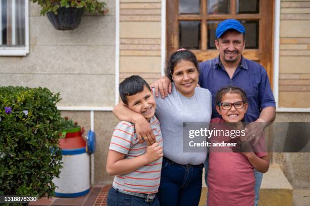 familia rural latinoamericana frente a su nueva casa - latinoamericano fotografías e imágenes de stock