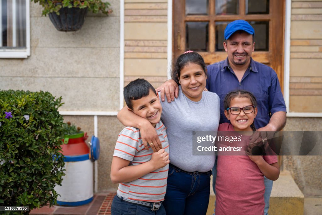 Rural Latin American family in front of their new house
