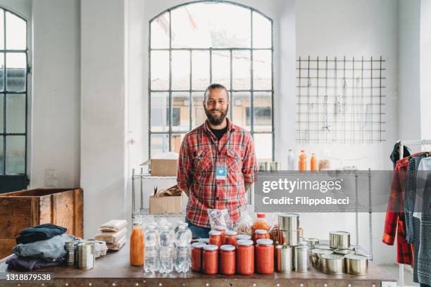 portrait of a volunteer at the table of the food and clothes bank - homeless shelter man stock pictures, royalty-free photos & images