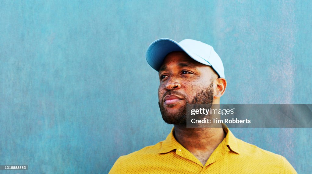Man in baseball cap looking off camera