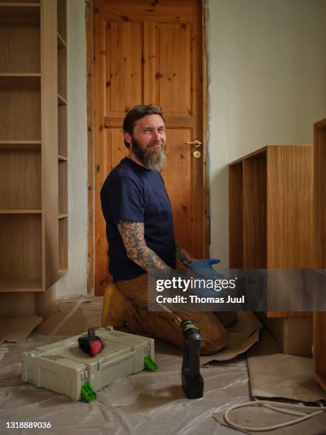 confident hipster carpenter working in kitchen - hipster in a kitchen stock-fotos und bilder