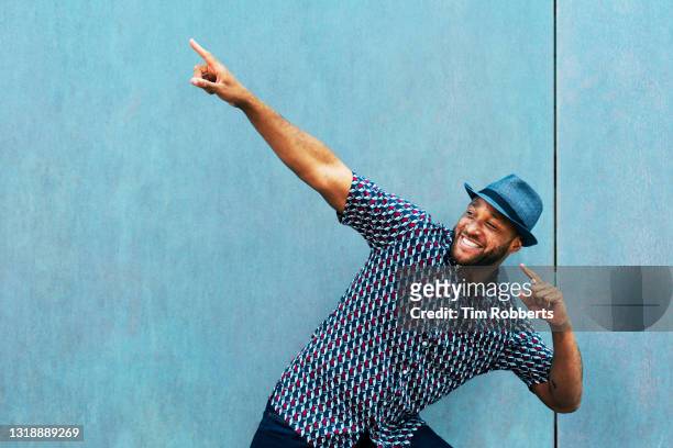 man doing a fun pointing gesture - cool attitude stockfoto's en -beelden