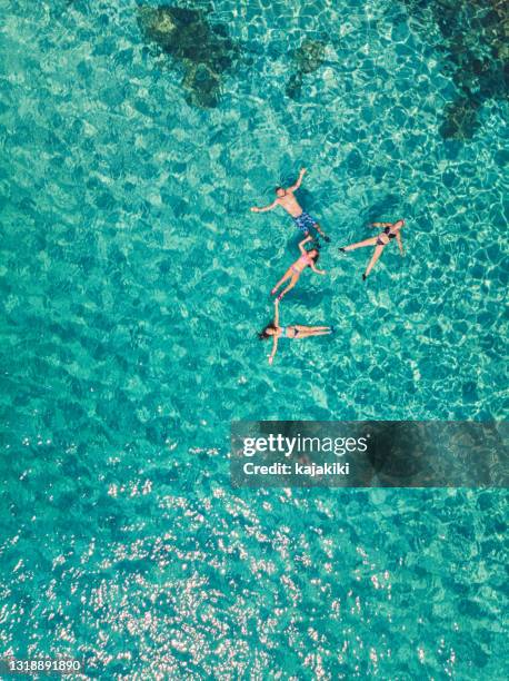 vista aérea de una familia joven flotando y nadando en hermosa playa en la isla griega - mar egeo fotografías e imágenes de stock