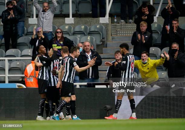 Joe Willock of Newcastle United celebrates with team mates Miguel Almiron, Paul Dummett and Joelinton after scoring his team's first goal during the...