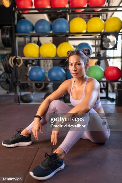 woman resting in gym after hard workout. wearing professional sport clothing. - gym resting stock pictures, royalty-free photos & images