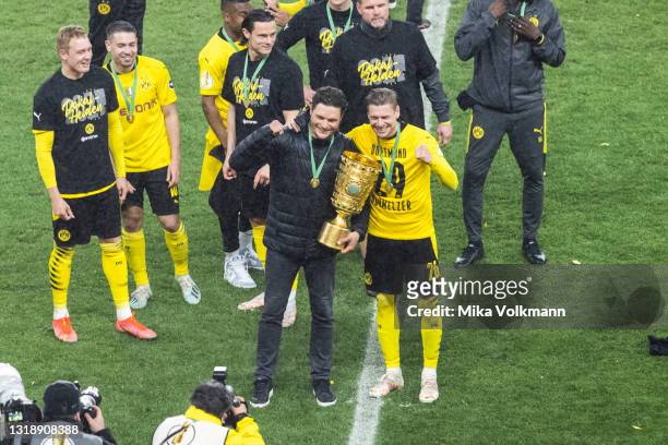 Head coach Edin Terzic of Dortmund and Lukasz Piszczek of Dortmund celebrate the win of the trophy during the DFB Cup final match between RB Leipzig...