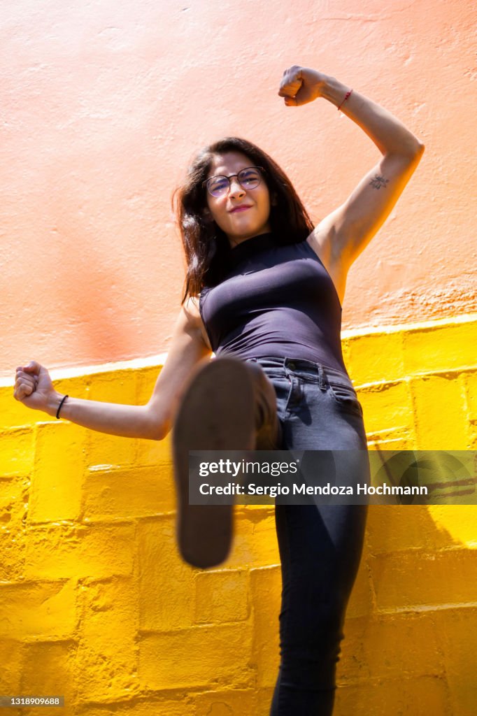Young Latino woman stepping on camera, low angle POV of camera