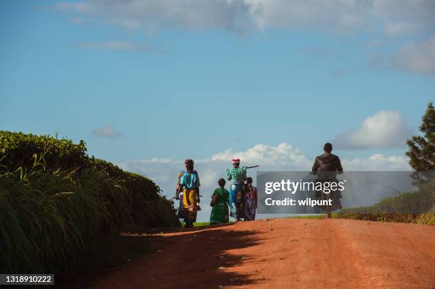 walking home and some on a motor bike rear view - malawi stock pictures, royalty-free photos & images