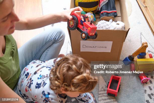 family preparing a box of toys to donate - homeless child stock pictures, royalty-free photos & images