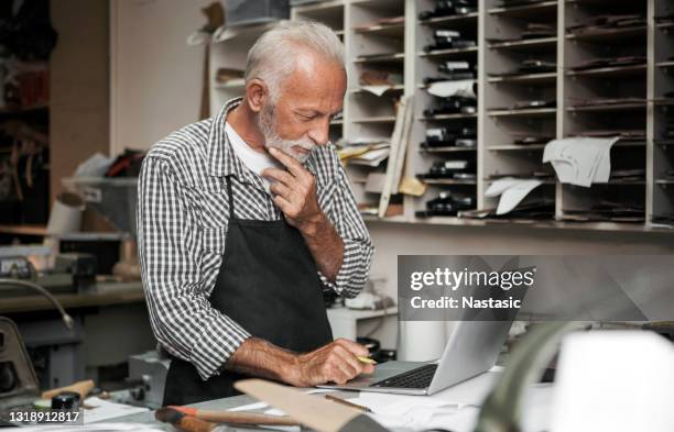 shoemaker making new boots in workshop ,making design on laptop - cobbler stock pictures, royalty-free photos & images