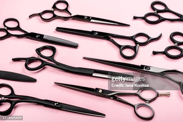 collection of different black hairdressing scissors on trendy pastel pink background. working tools for hairdressers. pattern. - hairdresser tools stock pictures, royalty-free photos & images
