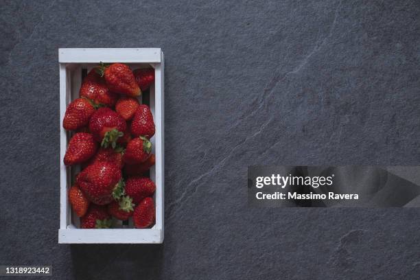 red strawberries on dark stone surface - pizarra roca metamórfica fotografías e imágenes de stock