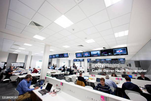 Formula One journalists and media representatives of the press work at their desks on laptop computers in the Silverstone Wing building's media room...