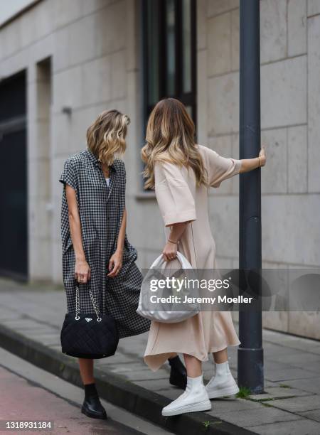 Carmen Kroll wearing rosé Acne Studios dress, white Bottega Veneta leather bag and white Copenhagen Studios boots and Justine Schlütter wearing...