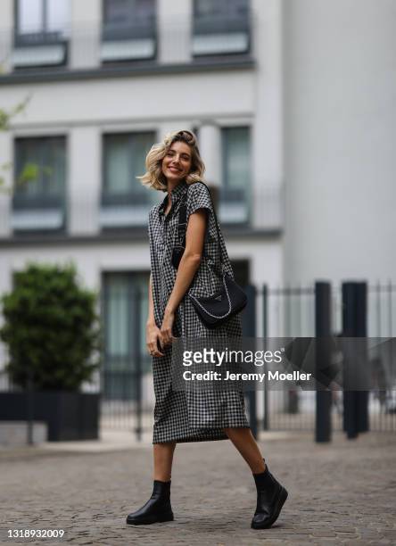 Justine Schlütter wearing checked grey and black Balenciaga dress, black Prada nylon bag and black Copenhagen Studios boots on May 11, 2021 in...