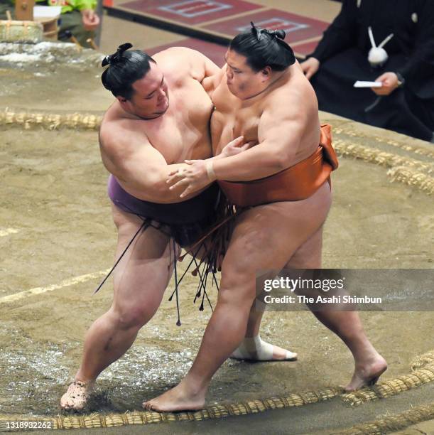 Ozeki Asanoyama pushes komusubi MItakeumi out of the ring to win during day ten of the Grand Sumo Summer Tournament at Ryogoku Kokugikan on May 18,...