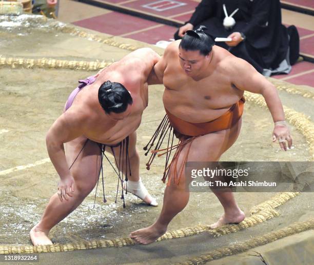 Ozeki Asanoyama pushes komusubi MItakeumi out of the ring to win during day ten of the Grand Sumo Summer Tournament at Ryogoku Kokugikan on May 18,...