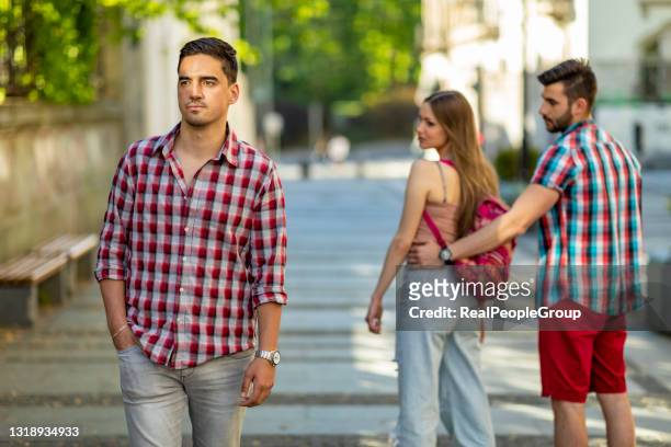 joven desleal mirando a otro hombre y su novio enojado mirándola en la calle - meme fotografías e imágenes de stock