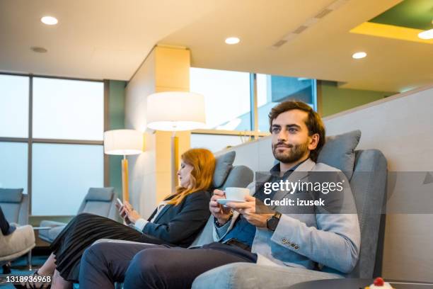 geschäftsmann beim kaffee trinken in der flughafen-lounge - abflugbereich stock-fotos und bilder