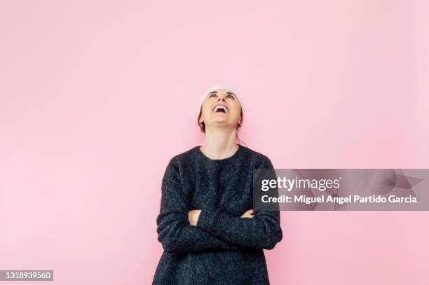 young woman with pink scarf looking up smiling with arms crossed.cancer concept - best bosom fotografías e imágenes de stock