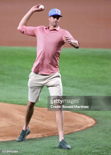 Tennis player, John Isner throws out the ceremonial first pitch before a game between the New York Yankees and the Texas Rangers at Globe Life Field...