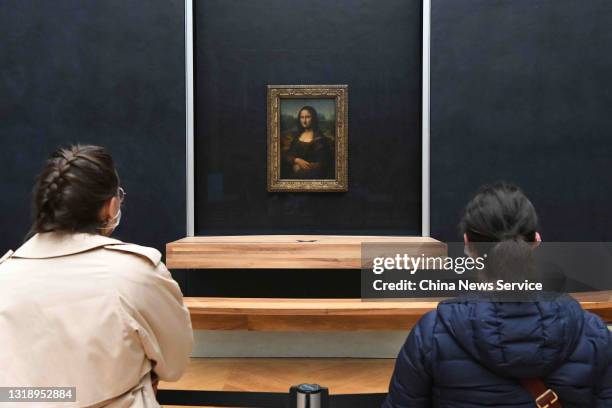 Visitors watch the painting 'Mona Lisa' at the Louvre Museum on its reopening day on May 19, 2021 in Paris, France. Louvre Museum reopened to the...