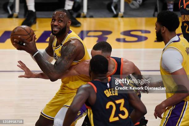 LeBron James of the Los Angeles Lakers controls the ball as Draymond Green and Stephen Curry of the Golden State Warriors defend during the first...